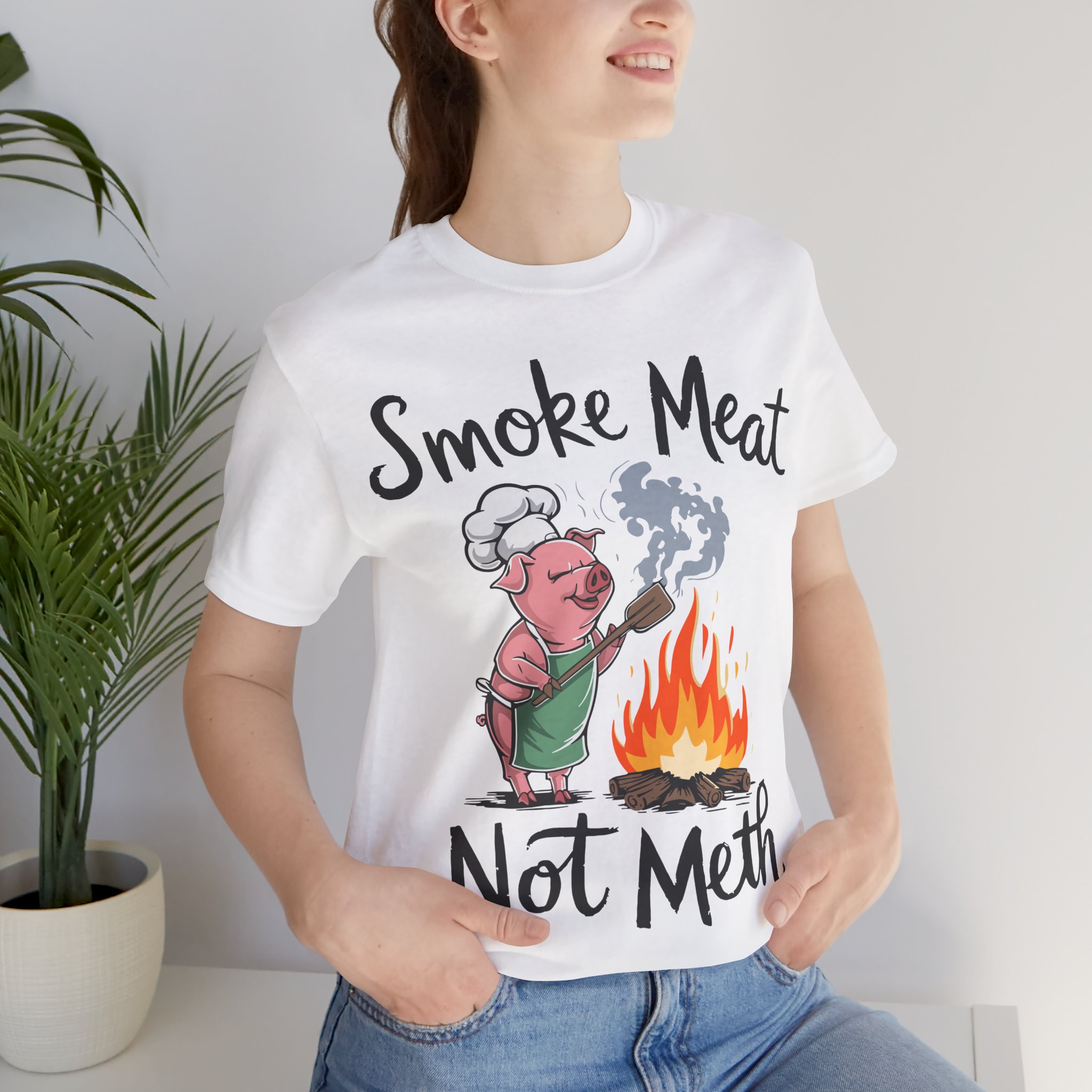 A humorous unisex short-sleeve t-shirt featuring the bold text 'Smoke Meat Not Meth,' perfect for BBQ lovers and grill masters who enjoy summer cookouts and foodie humor.